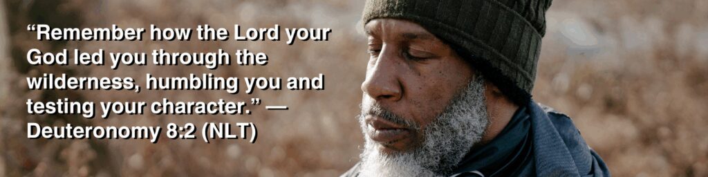 A reflective man in a beanie sitting outdoors with autumn tones behind him, paired with the Bible verse “Remember how the Lord your God led you through the wilderness, humbling you and testing your character” from Deuteronomy 8:2.