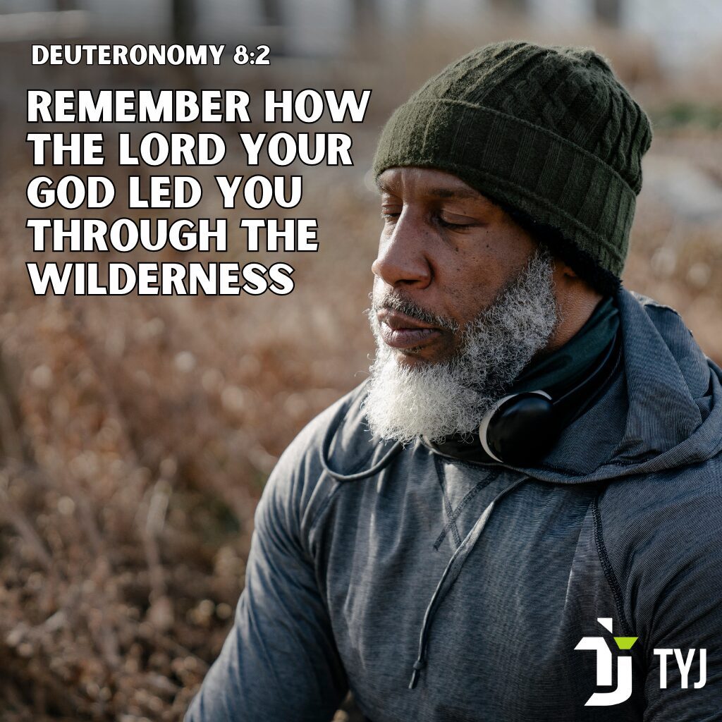 Man reflecting outdoors with the scripture Deuteronomy 8:2 about God leading through the wilderness.